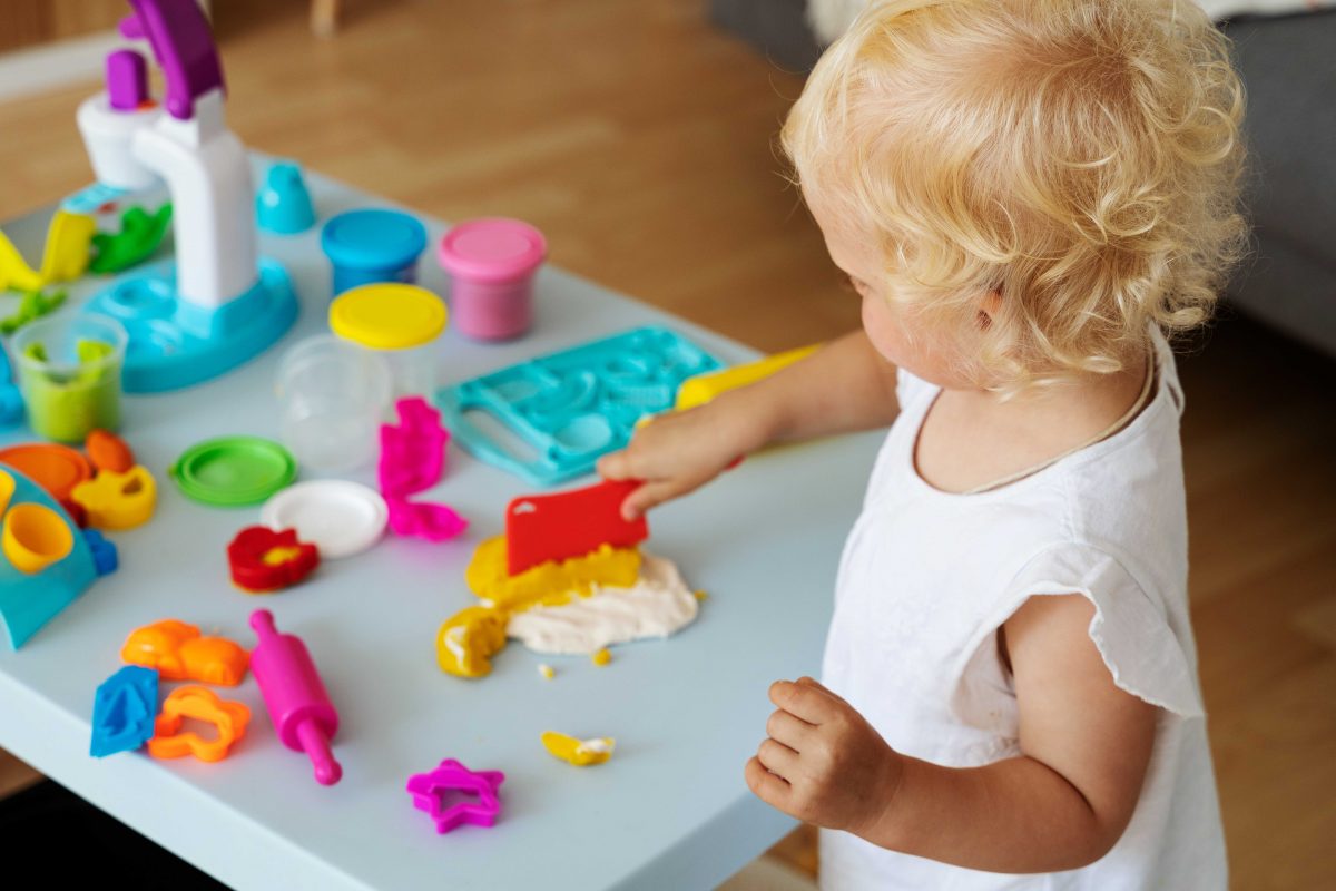 photo petite fille qui joue avec de la pâte à modeler